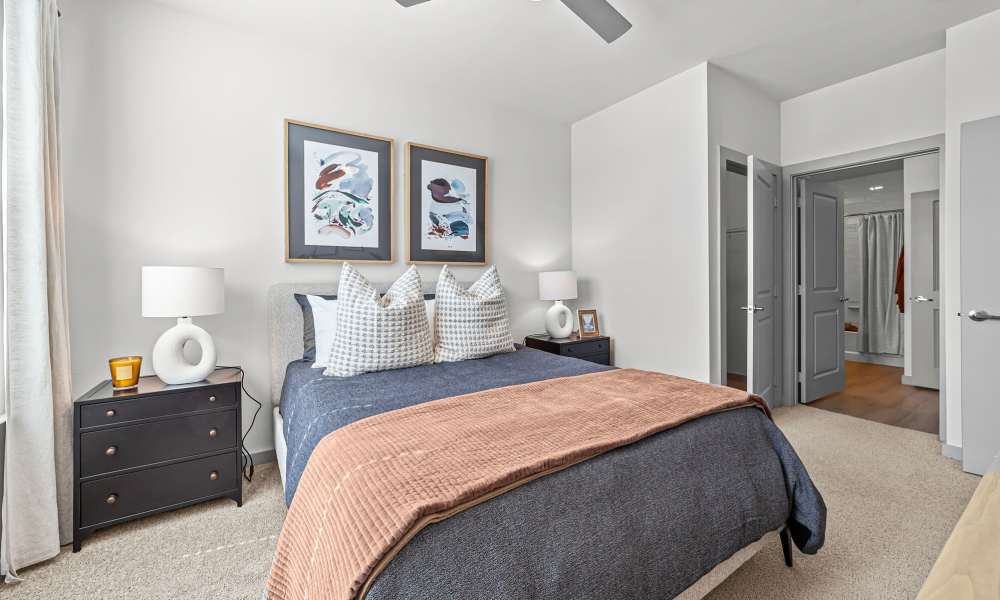 Bedroom with a ceiling fan and bright interiors at Main and Mill in Lewisville,Texas