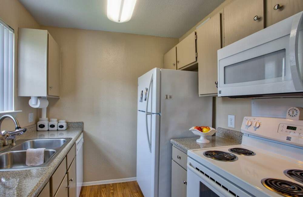 Apartment kitchen with modern appliances at The Pines of Palos Verdes in Mesquite, Texas