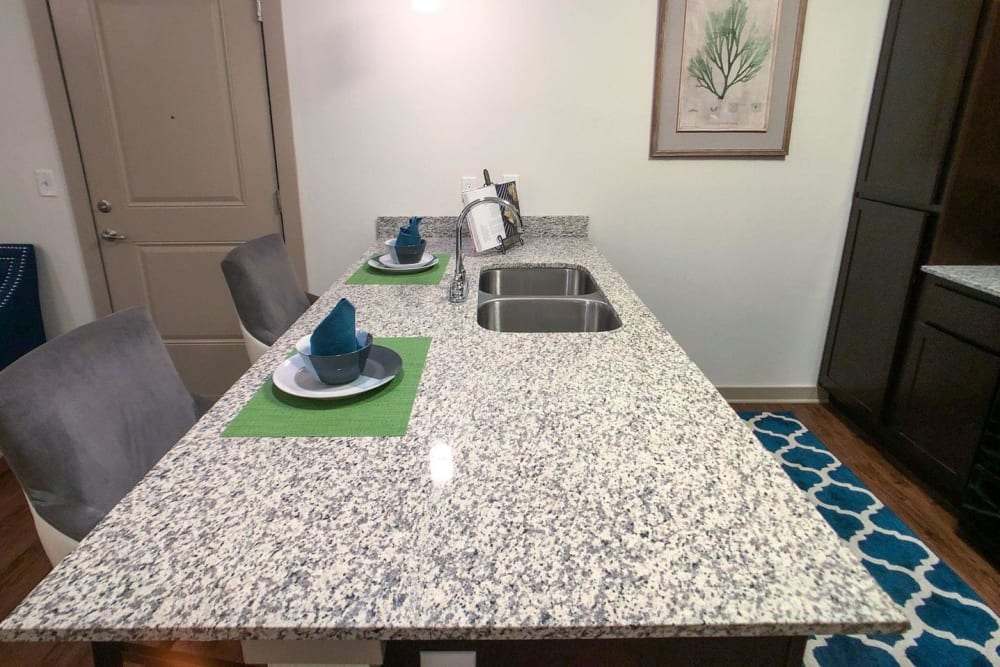 Kitchen island with bar seating and granite countertops at Anatole on MacArthur in Oklahoma City, Oklahoma