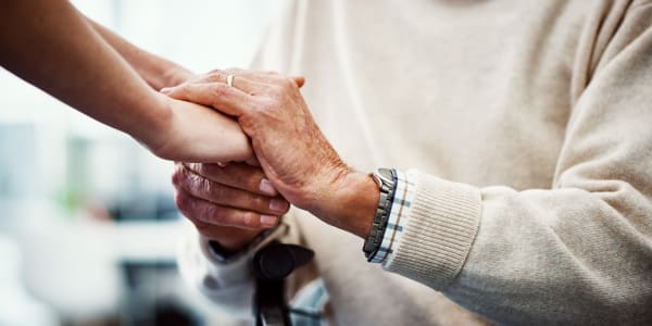 Resident holding hands with their caretaker at Geneva Lake Manor in Lake Geneva, Wisconsin