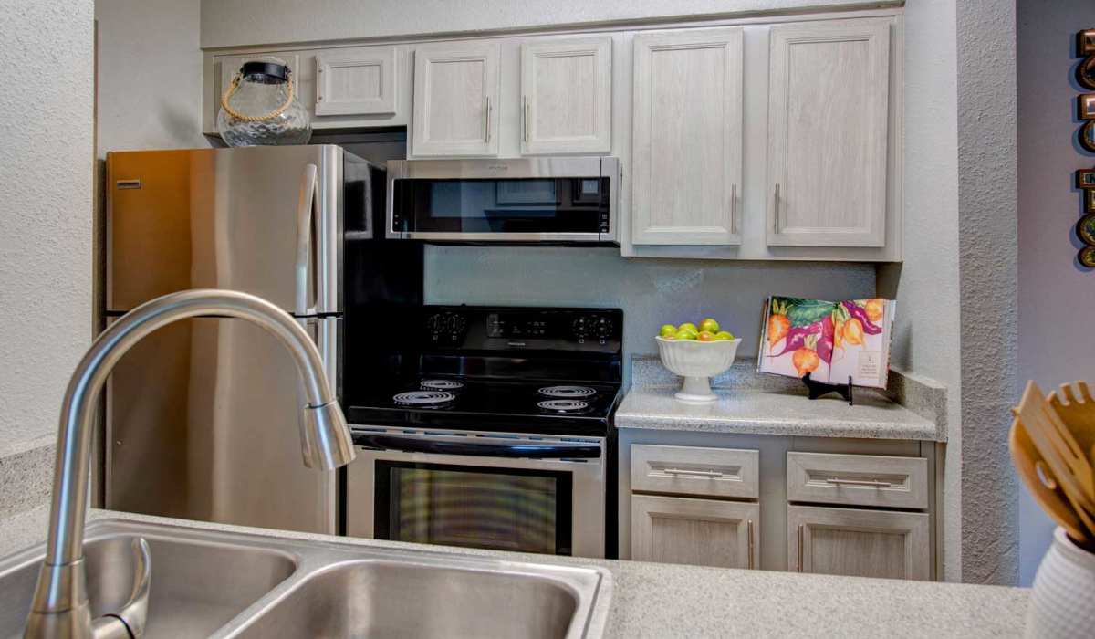Kitchen faucet sink and granite countertops at University Green Apartments in Houston, Texas