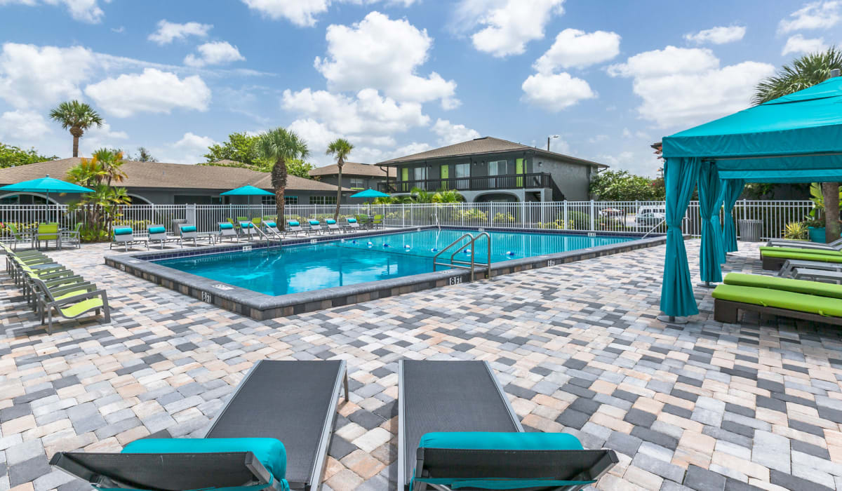 Resort-style swimming pool with lounge chairs and cabanas at Central Place at Winter Park in Winter Park, Florida