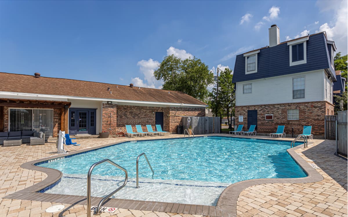 Swimming pool with lounge chair at Stonebridge Manor Apartments in Gretna, Louisiana