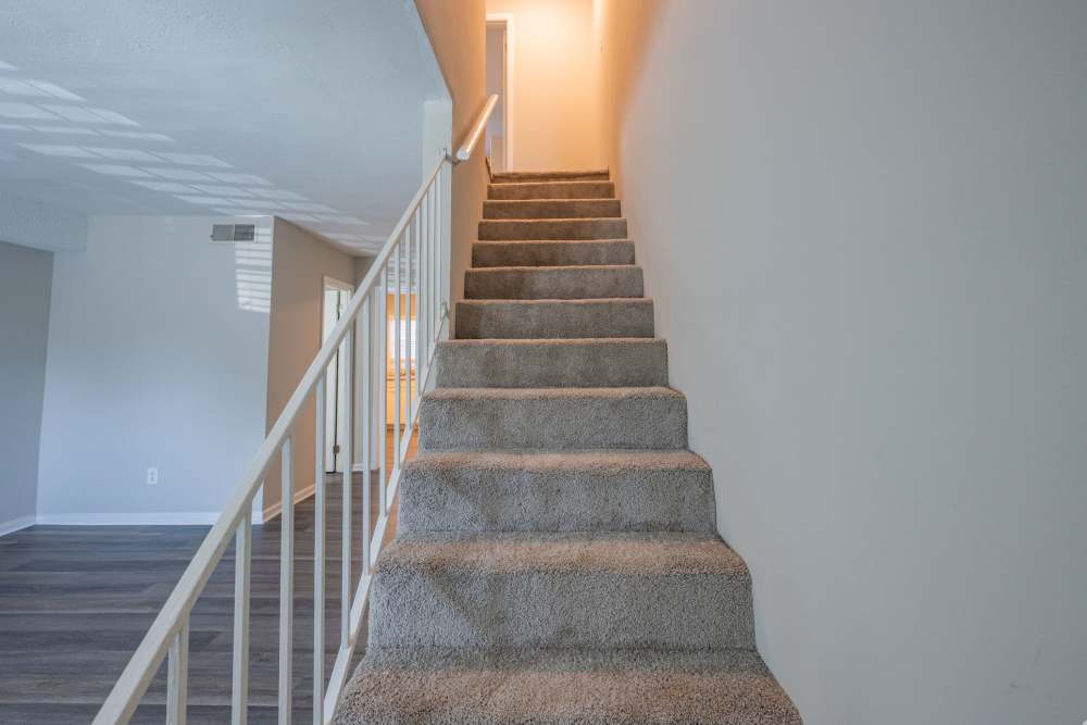 Unfurnished living room with staircase at Ivey Ridge Apartments in Graham, North Carolina