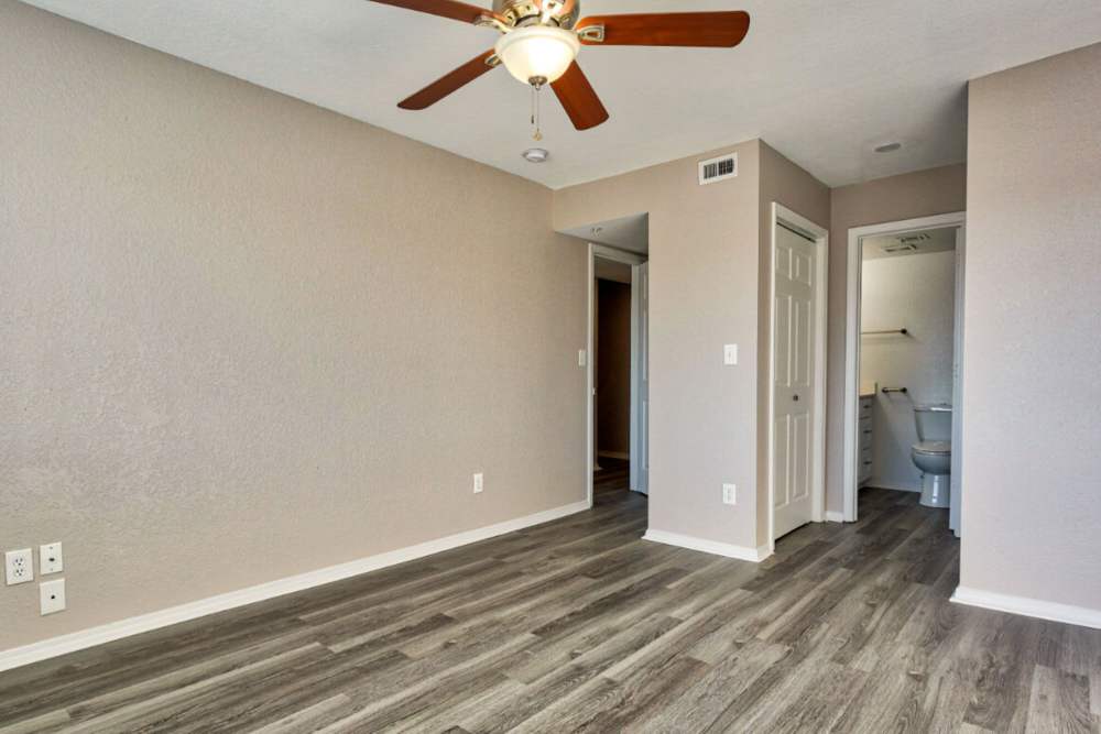 Unfurnished bedroom with ceiling fan and attached bathroom at Lake Hefner Townhomes in Oklahoma City, Oklahoma