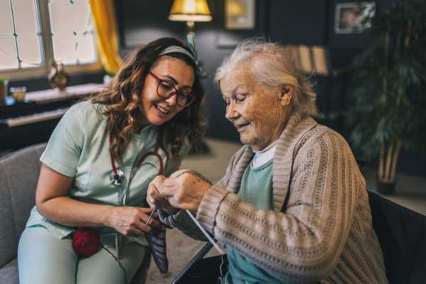 Resident getting personal care from a nurse in her apartment at The Birches at New Hope in New Hope, Pennsylvania