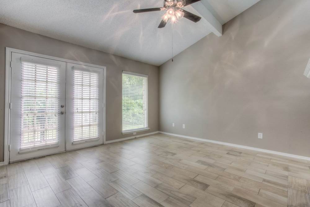 Unfurnished living with wood flooring, french glass door and ceiling fan at The Quorum At Trophy Club in Trophy Club, Texas