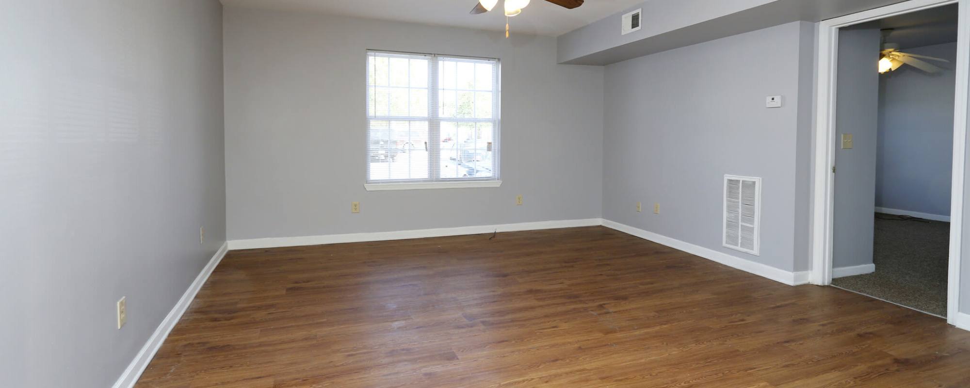 Unfurnished living room with wood-style flooring at Alston Arms Apartments in North Charleston, South Carolina