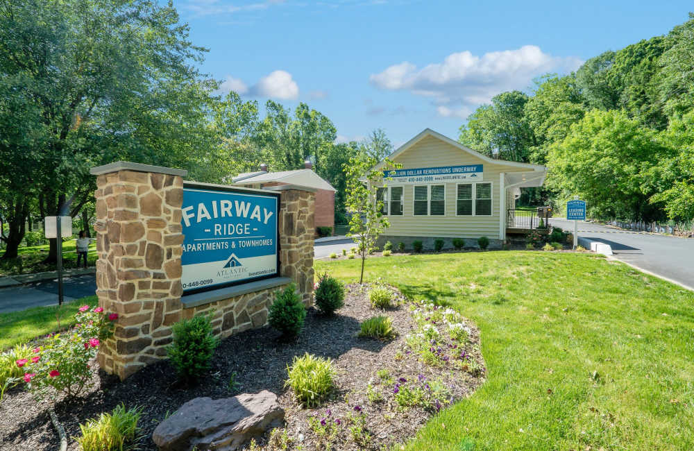 Welcoming entrance to Fairway Ridge with landscaped gardens and a stone sign at Fairway Ridge in Baltimore, Maryland