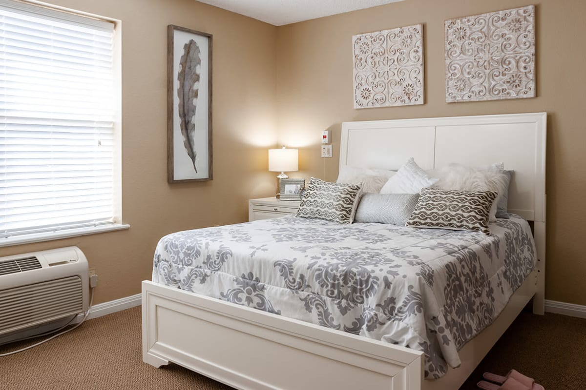 Bed with large window in bedroom of a unit at Cimarron Place in Midland, Texas