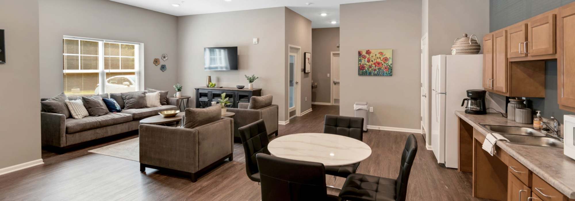 Community room with kitchen and seating area at Magnolia Greene in Lavale, Maryland