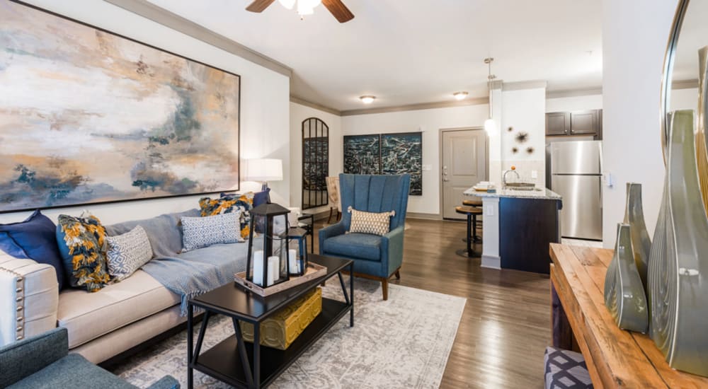 Leather couch and a comfortable chair in a model home's living space at Alden Park Kingsland in Houston, Texas