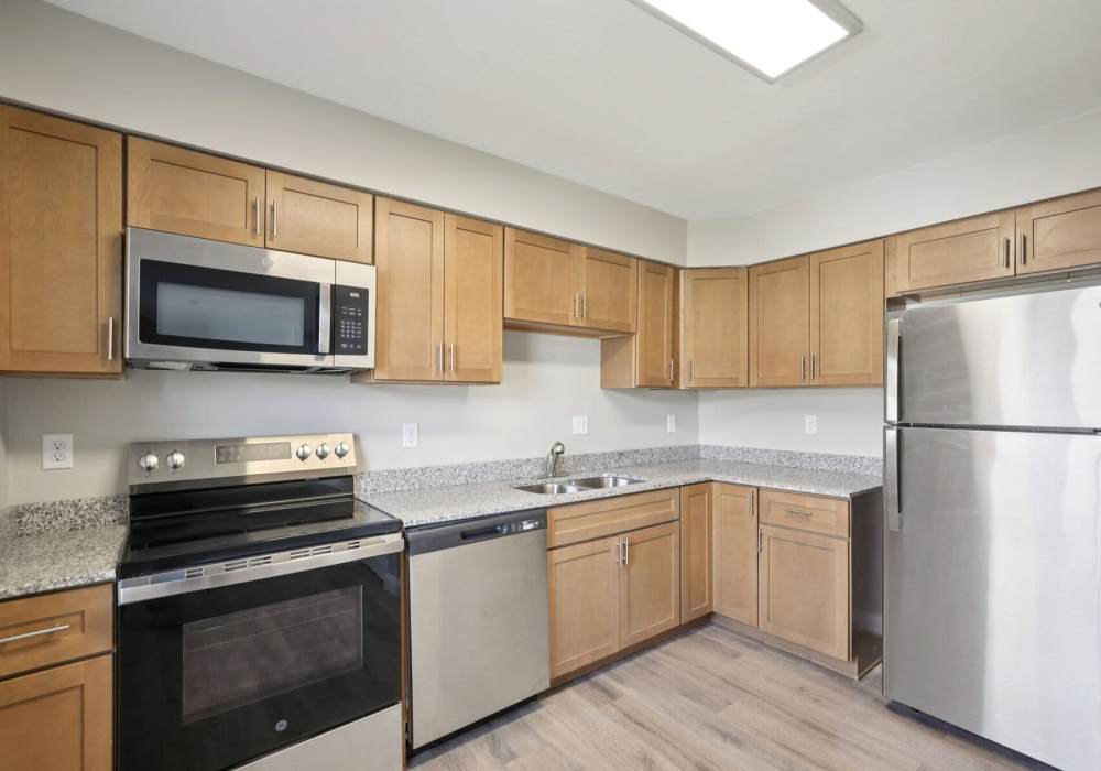 modern kitchen with steel appliances and wooden flooring at Charleston Square Apartments in Columbus, Indiana
