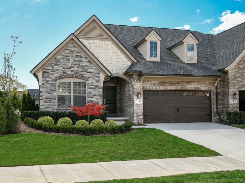 Duet home with a wide driveway and a personal lawn at Blossom Ridge in Oakland Charter Township, Michigan