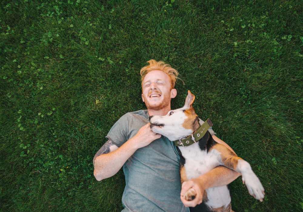 Man and pup laying in grass at Cedarcrest Village in Lexington, South Carolina