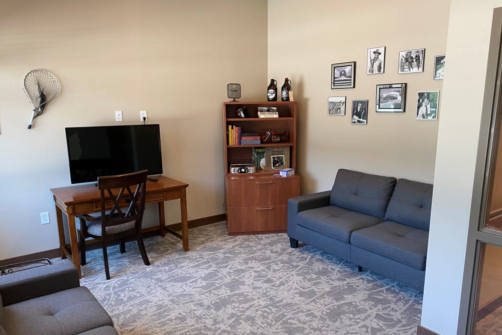 Sitting area with modern couches and TV at Country Meadow Place in Mason City, Iowa