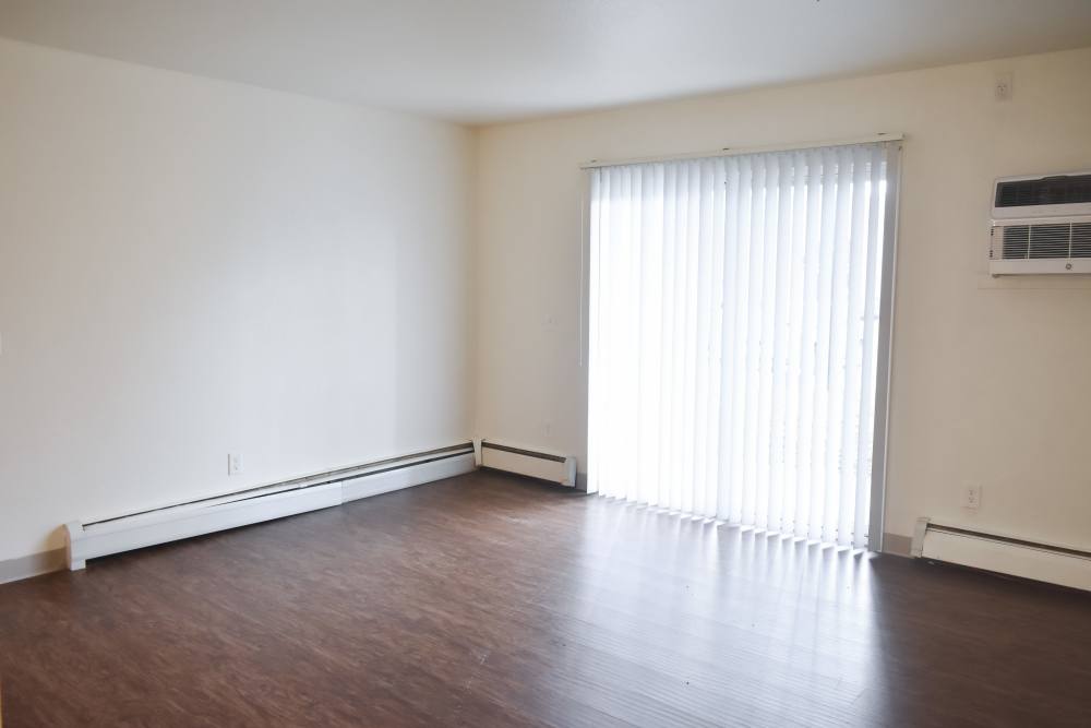 Unfurnished living room with window access at Clairewood Apartments in Saint Clair, Michigan