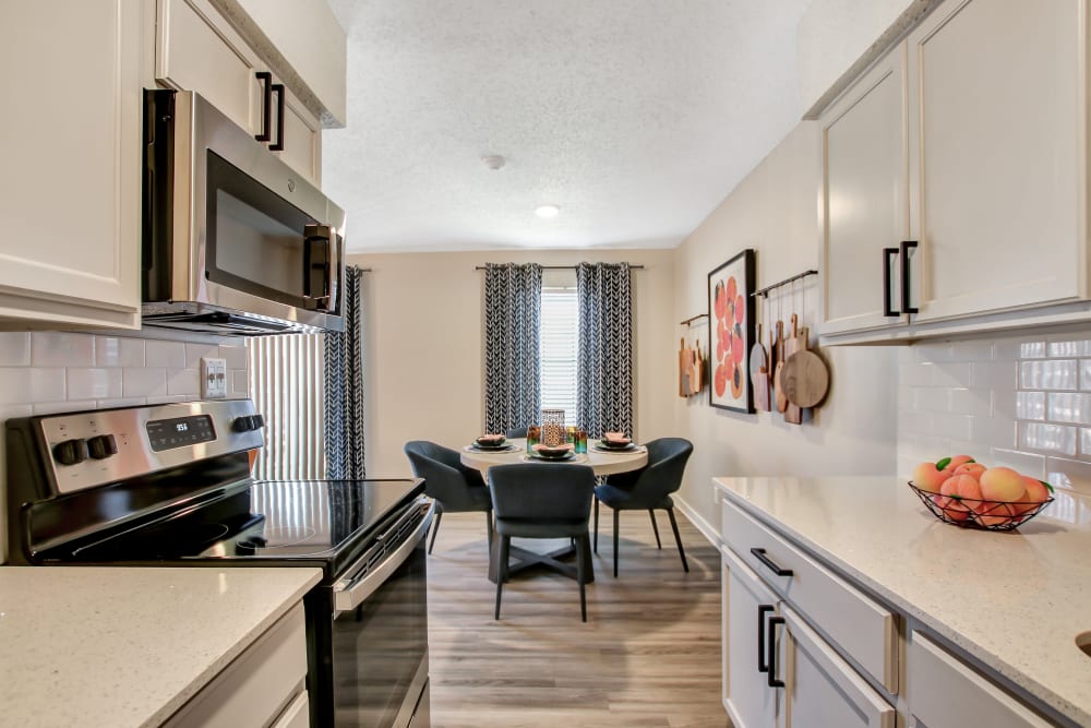 White cabinet and countertop kitchens with dining area at Lockhart Apartment Homes in Mesquite, Texas