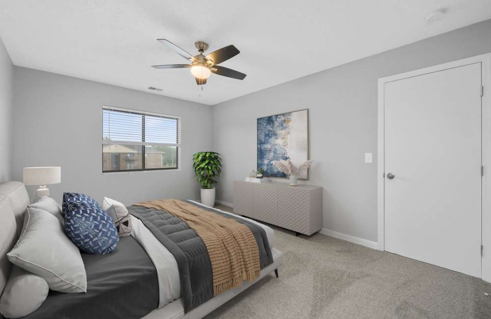 Large bedroom with ceiling fan and window at Indian Footprints Apartments in Harrison, Ohio