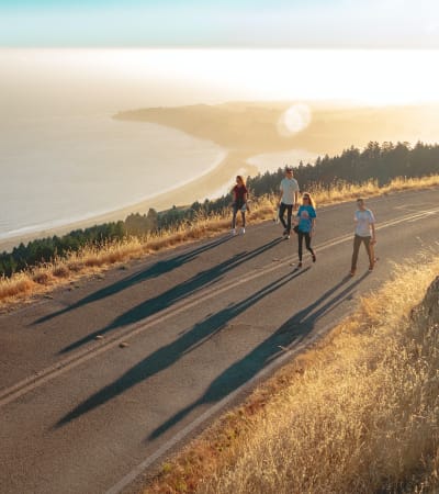 A group of friends walking on a hill overlooking the beach near The Villas at Anacapa Canyon in Camarillo, California