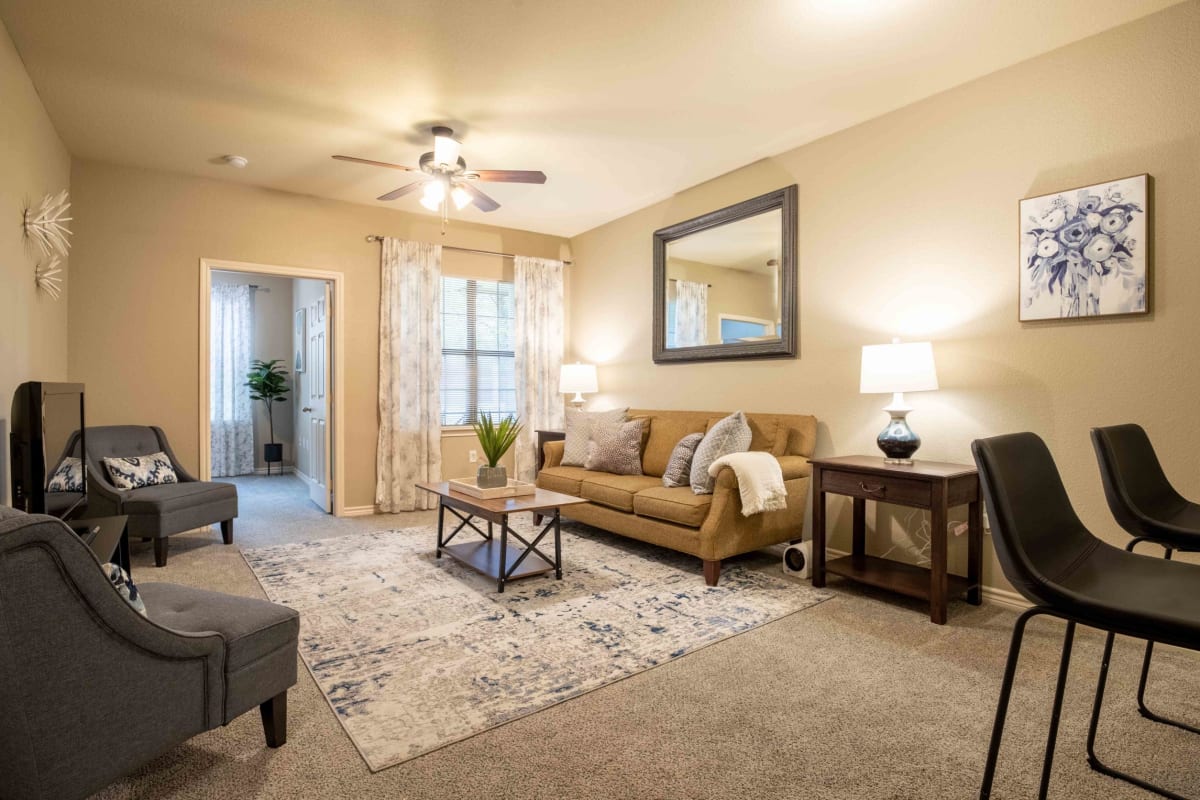 Living room with a ceiling fan at Parc At Rogers in Rogers, Arkansas