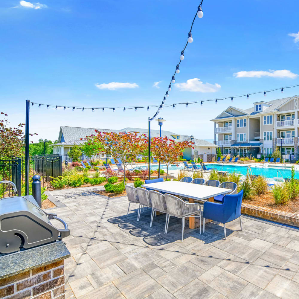 An outdoor grilling area with dining seating at The Highland in Augusta, Georgia