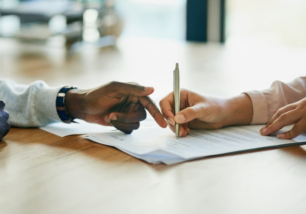 People signing a document at Ari Apartment Management