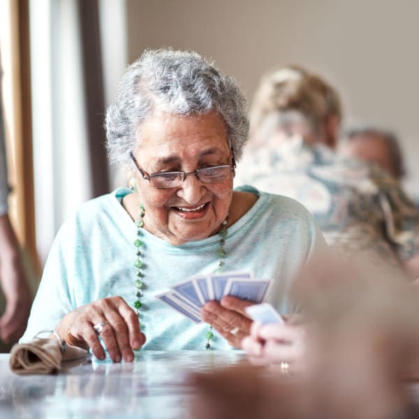 Woman playing cards at The Crest at Citrus Heights in Citrus Heights, California