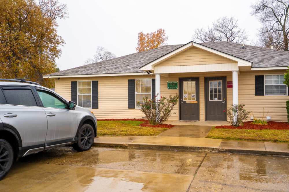 Exterior view of the community with parked car at Liberty Village in Monroe, Louisiana
