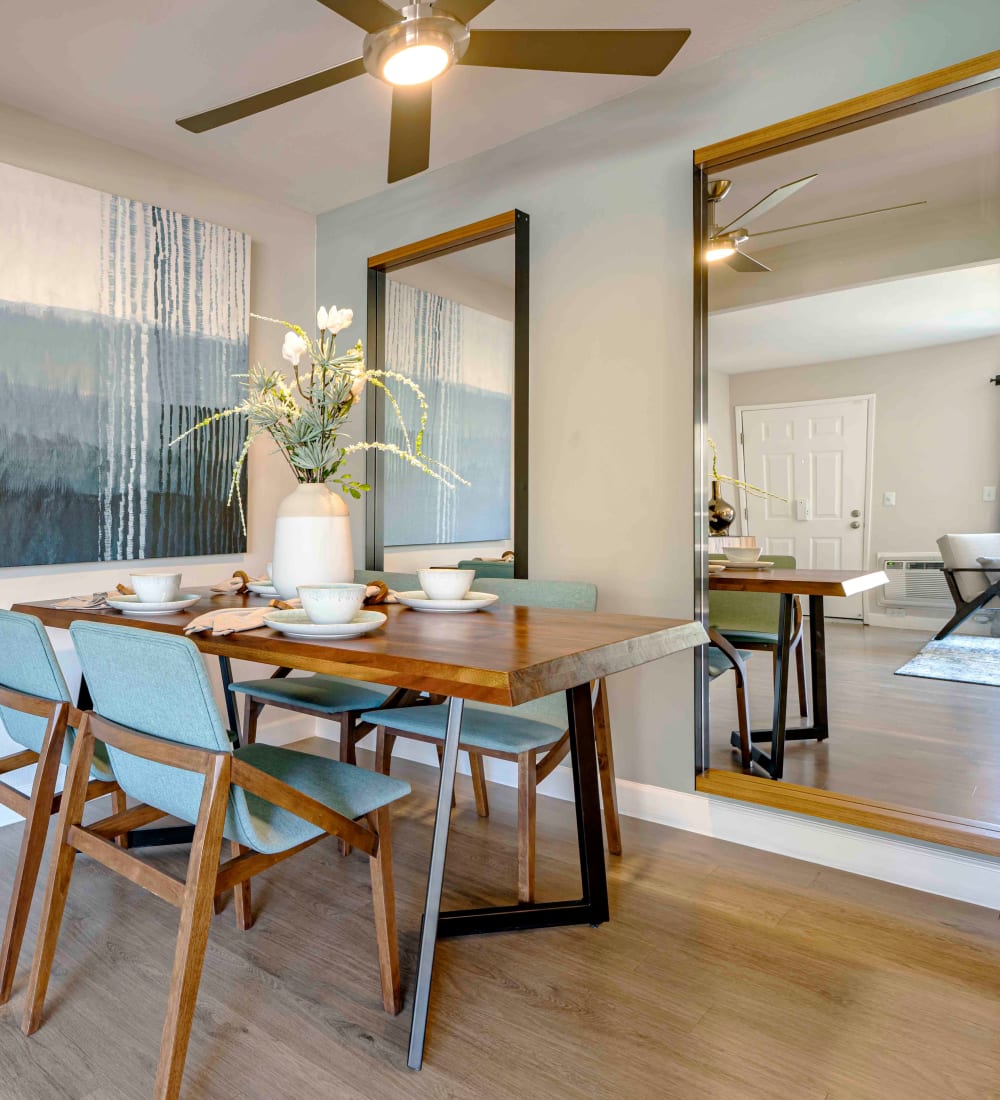 Open-concept living area with a ceiling fan over the dining area next to the kitchen in a model home at Sofi Berryessa in San Jose, California