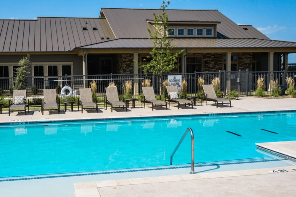 Sparkling swimming pool and sunny poolside lounge chairs at Anatole on MacArthur in Oklahoma City, Oklahoma