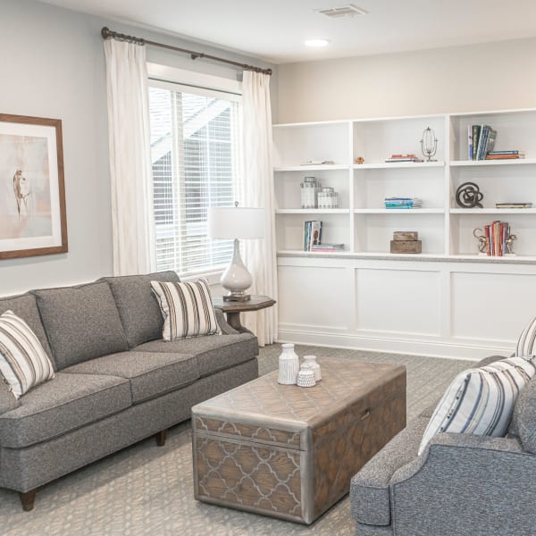 Resident living room with two sofas and a bookshelf in the background at The Madison Senior Living in Kansas City, Missouri