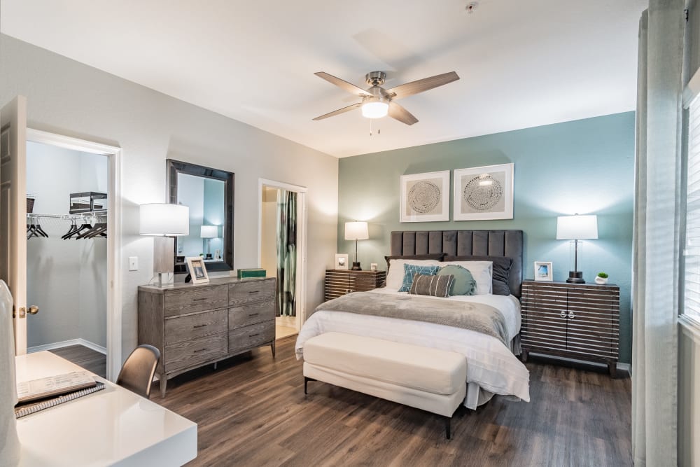 Spacious apartment bedroom with large bed and multiple art prints on the wall at The Parq at Cross Creek in Tampa, Florida