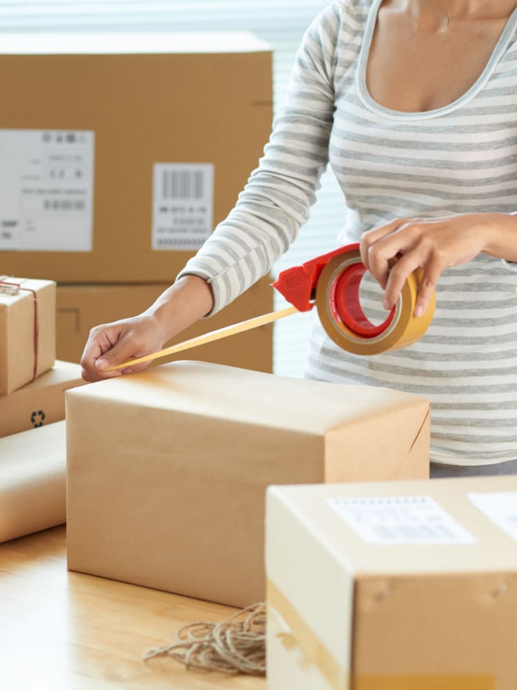 A lady packing a moving box at Store It All Self Storage