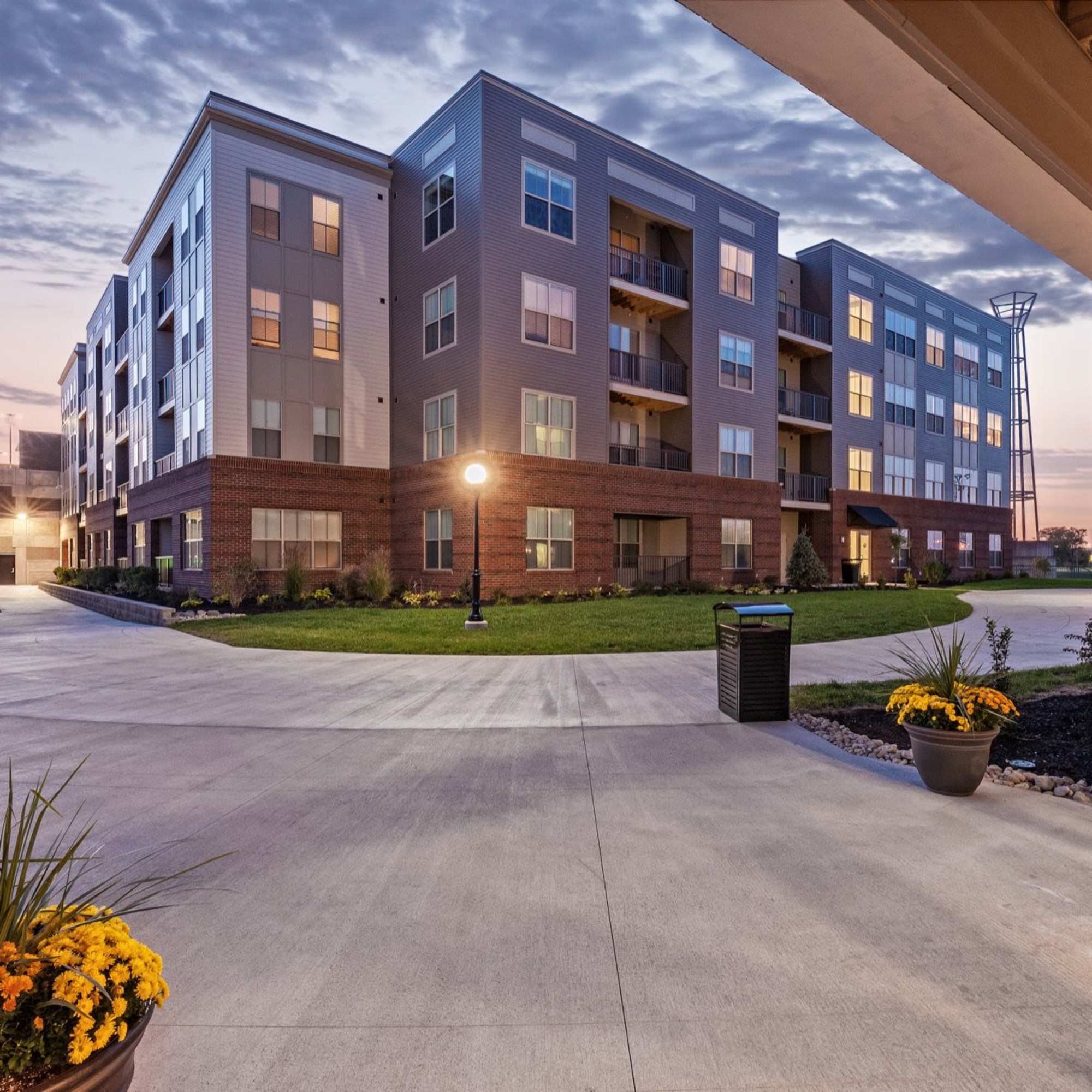 Modern apartment community with landscaped grounds, outdoor lighting, and balconies on upper floors at Water Street Apartments in Dayton, Ohio