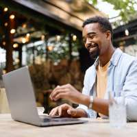 Resident working in his laptop at a restaurant near Pine Oaks Apartments in Mesquite, Texas