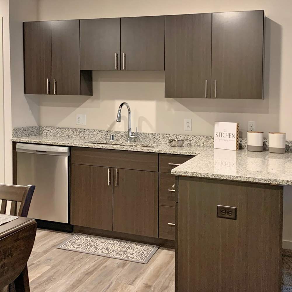 Kitchen with granite countertop and wood cabinet at Depot on Main in Zimmerman, Minnesota