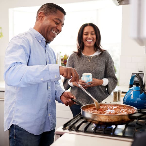 Happy residents cooking their apartment home at Acclaim at the Hill, Fredericksburg, Virginia