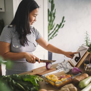 Resident preparing a meal in her new kitchen at Franciscan Apartments in Garland, Texas