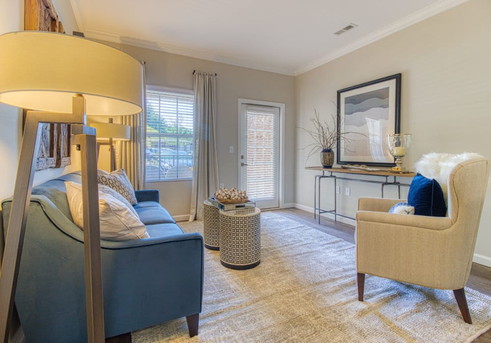 Sheek living room with mid-century style chair and couch with access to balcony or patio at Greymont Village in Asheville, North Carolina