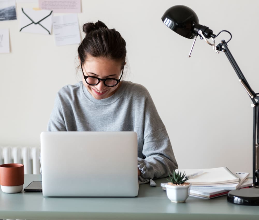 Resident student doing some homework on her laptop at Terra Apartment Homes in Federal Way, Washington