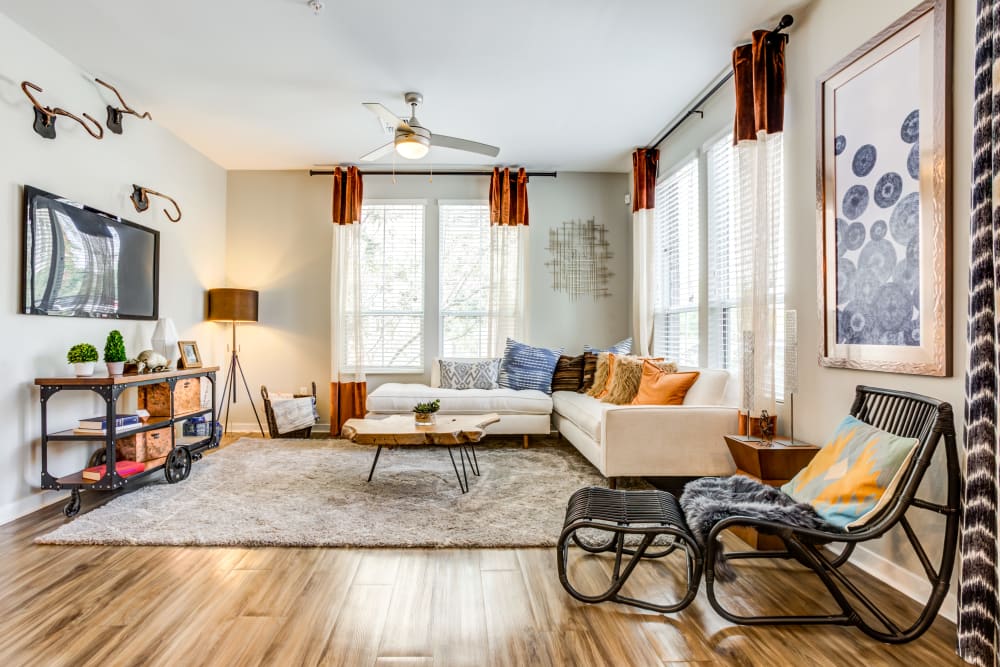 Model living room with vinyl plank flooring and a ceiling fan at Town Commons in Gilbert, Arizona