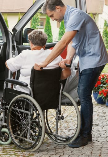 A staff member helping a resident into a car at The Claiborne at Hattiesburg Assisted Living in Hattiesburg, Mississippi. 