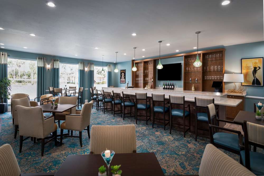Dining room with chairs and tables at The Pineapple House at Sapphire Lakes in Naples, Florida