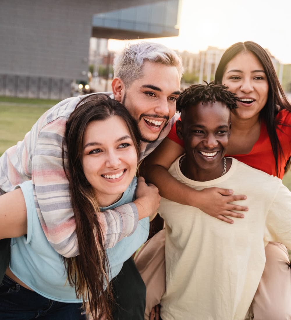 Student friends posing for a photo outside of Binghamton University near 20 Hawley in Binghamton, New York