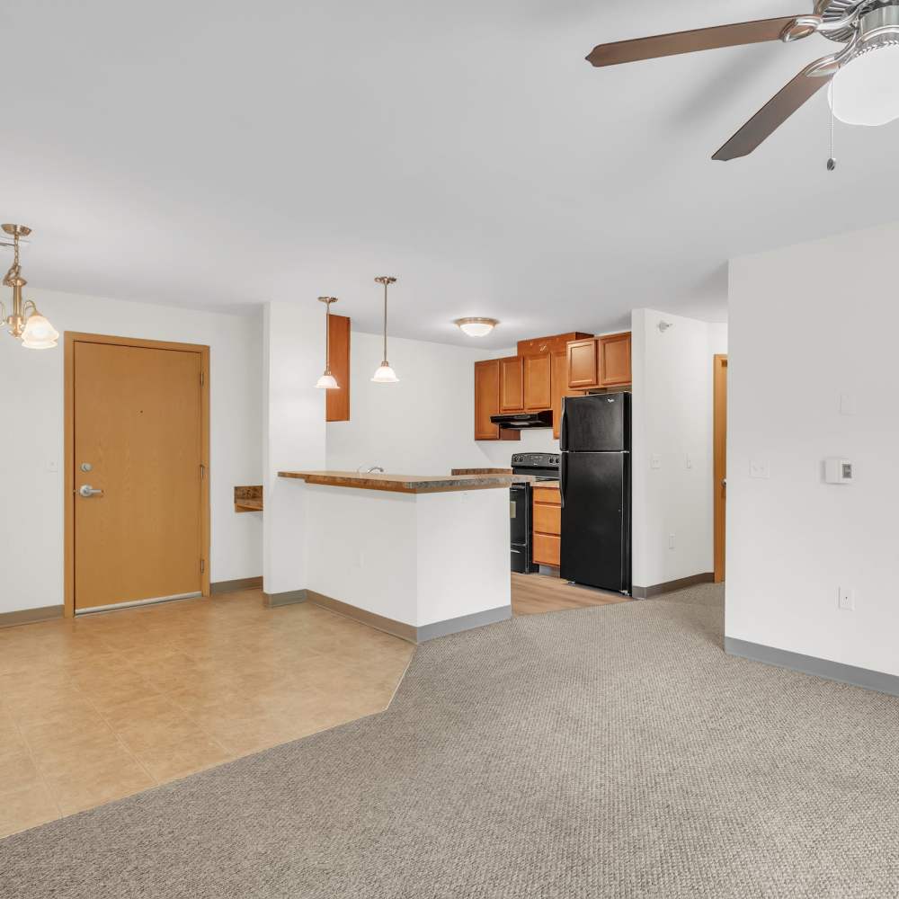 Unfurnished living room with view of kitchen at Residences on Main in Twin Lakes, Wisconsin