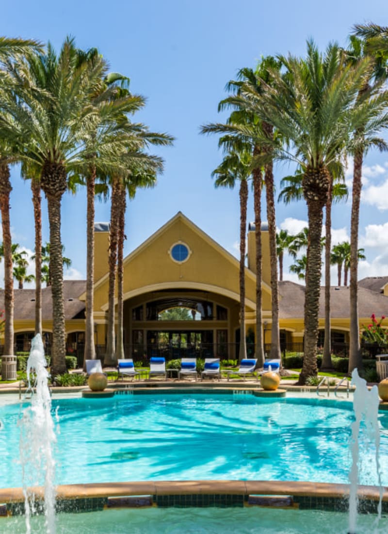 Sparkling resort style pool with water features and lounge chairs at Marquis at Clear Lake in Webster, Texas