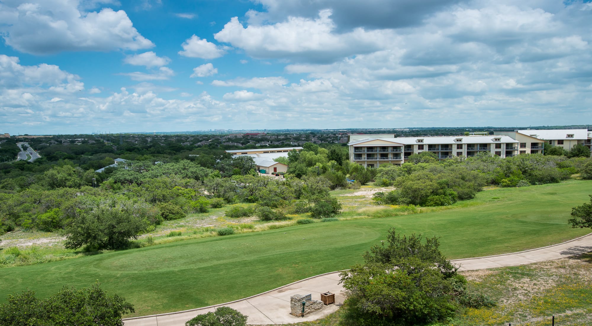 Lush green grass field and building exterior at Villas in Westover Hills in San Antonio, Texas