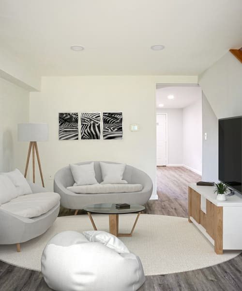 Cozy living room with modern furniture, wood-style flooring, and stylish decor at Dutch Village Apartments in Baltimore, Maryland