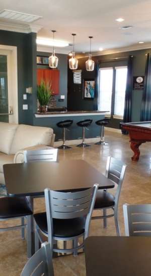 Clubhouse with seating and pool table at The Abbey at Stone Oak in San Antonio, Texas